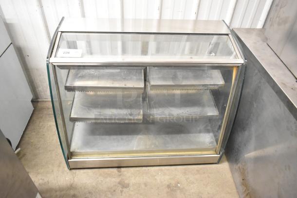 Metal commercial countertop display case with a glass front, featuring multiple shelves. Item tag reads "226". Good condition.