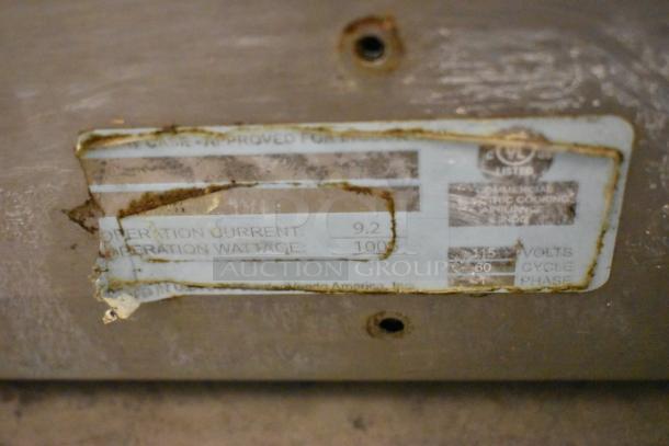 Metal Commercial Countertop Display Case Merchandiser with visible wear. Tag shows electrical specs: 9.2 operation current, 1000 watts, 115 volts.