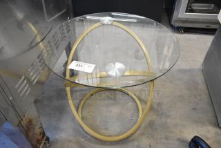 Gold finish table with round glass tabletop, modern circular base design. Auction tag number 231 visible. Good condition.