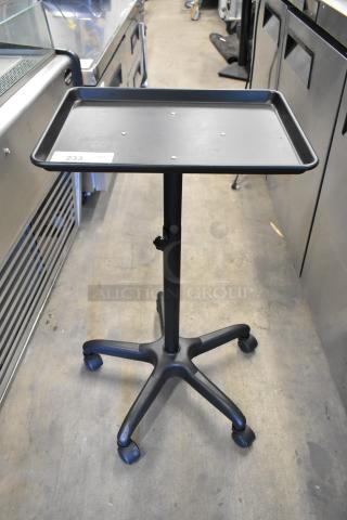 Tray dolly on casters, black, adjustable height with five-wheel base, identification tag labeled "233."