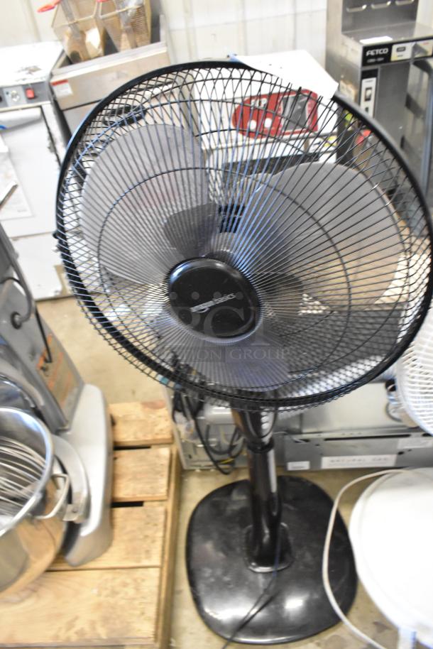 Black floor fan with black base, labeled "Comfort Zone," 120 volts, 1 phase, in used condition.