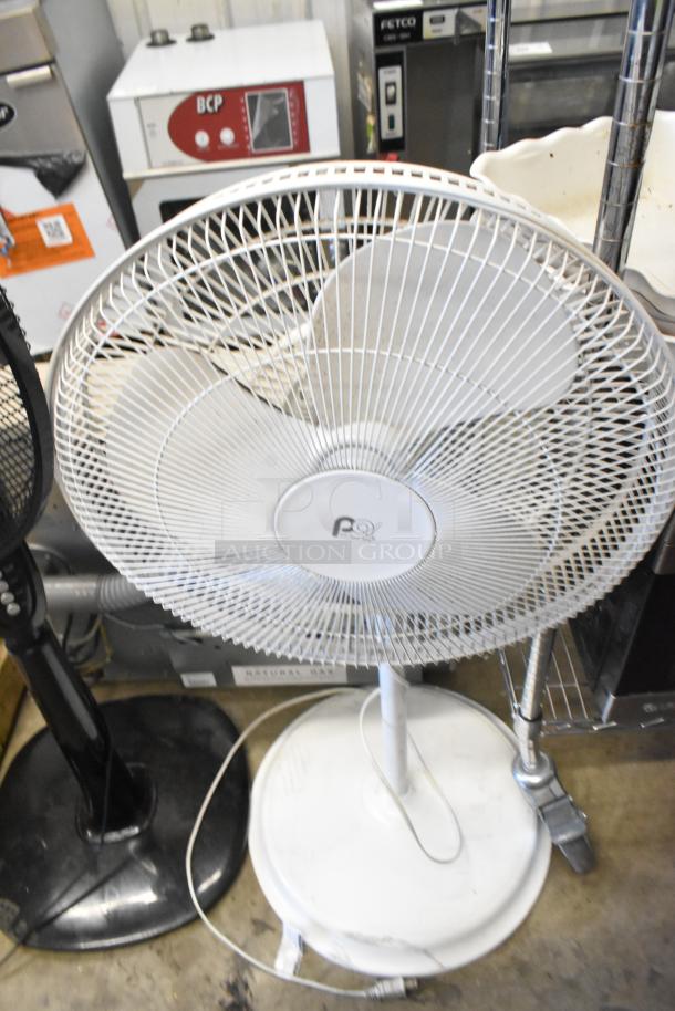Two floor style fans, 120 volts, 1 phase. White fan with three blades, circular base. Includes two identical units for double bid.