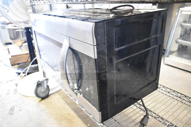 LG LMV1762ST stainless steel microwave oven, 120 volts, 1 phase, includes plate, visible wear, on wire rack.