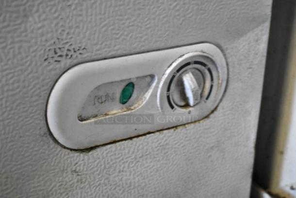 Close-up of Magic Chef HMCF7W4 chest freezer control panel, showing temperature dial and run indicator light.