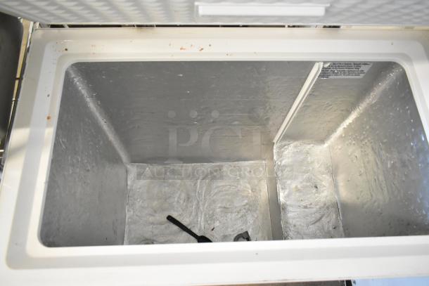 Magic Chef HMCF7W4 chest freezer with hinge lid, showing spacious interior, used condition with minor markings.