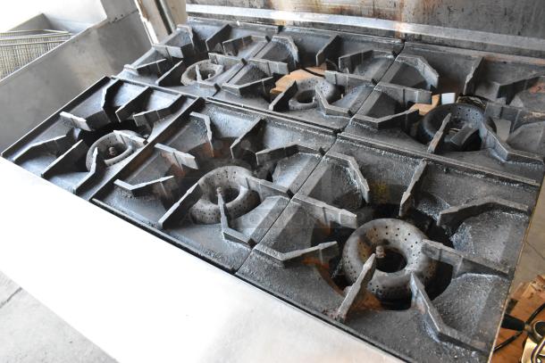 American Range stainless steel commercial 6-burner gas range with oven, salamander cheese melter, and back splash.