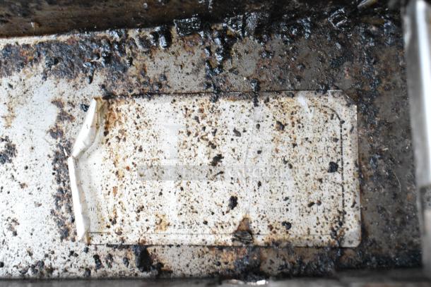 Worn label with text partially obscured by grime, possibly indicating model or specifications of American Range appliance.