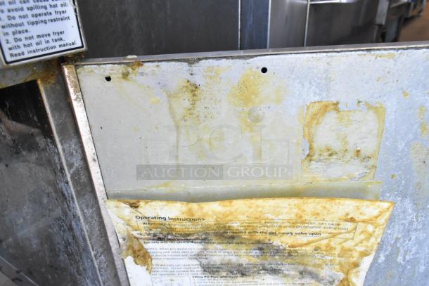 Cecilware stainless steel commercial floor deep fat fryer, used condition, with two metal fry baskets. Operating instructions label shows signs of wear.