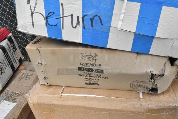 Damaged cardboard box labeled Lancaster Table & Seating, containing 22"x22" cast iron table base plates. Box marked "Return."