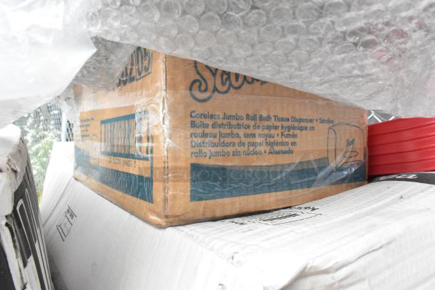 5 new scratch and dent items, including Scott coreless jumbo toilet paper dispenser box, visible through bubble wrap.