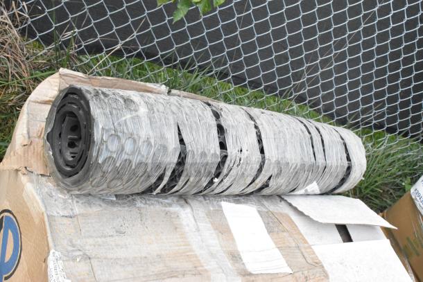 Black floor mat roll, brand new, partially wrapped, includes 9 scratch and dent items in original packaging.