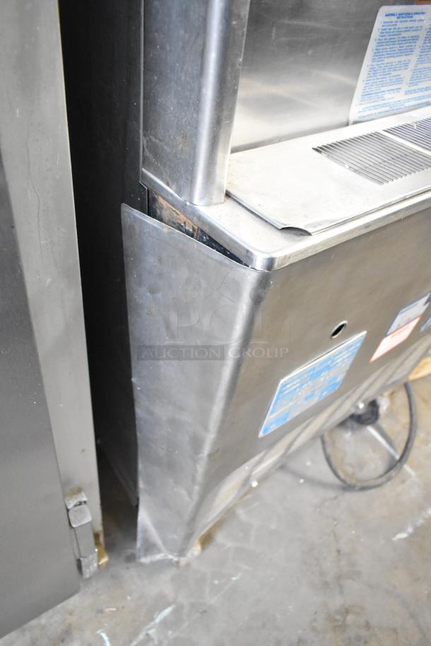 Taylor 754-27 stainless steel soft serve ice cream machine, 2 flavor with twist, on commercial casters, visible labels.
