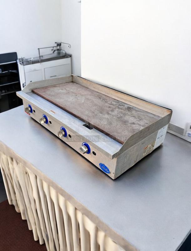 Globe 48" Commercial Gas Griddle, excellent condition, fully tested. Features blue knobs and grease trap, marked "Globe."