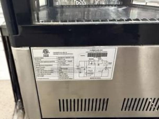 Omcan DW-CN-0200 refrigerated display case, pristine condition, 115V. Features visible manufacturer label with specifications.