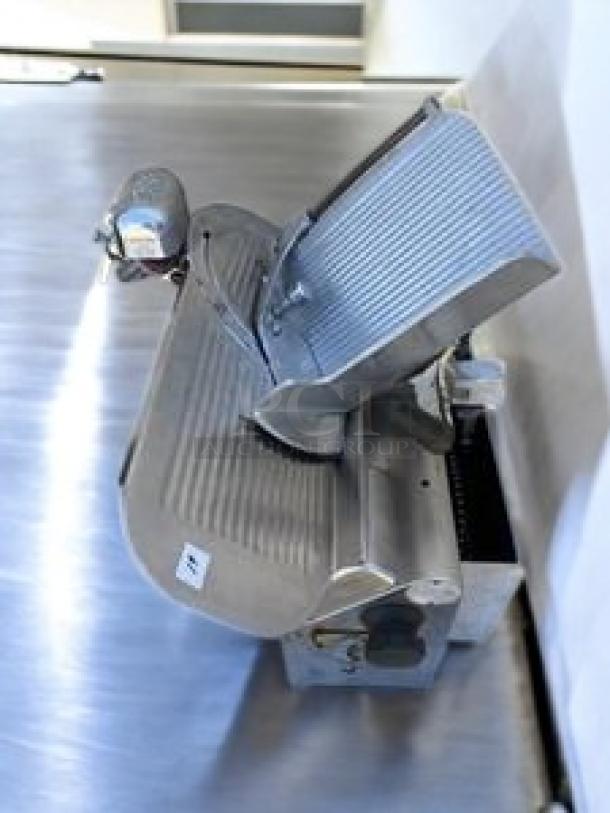 Globe commercial heavy-duty meat slicer in first-rate condition on a stainless steel surface. Model features include automatic/manual modes, tested and working.