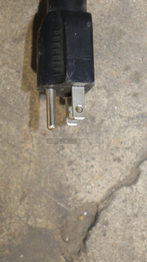 Close-up of a black power plug for the VEVOR YKF-8216T soft ice cream machine, showing prongs and cord.