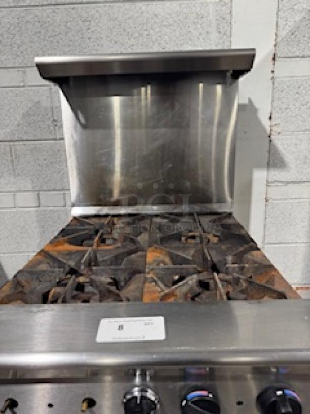 Tri-Star TSR-4 24" commercial gas range, 4 heavy-duty burners, 33,000 BTUs each, chrome rack, storage base, used condition.