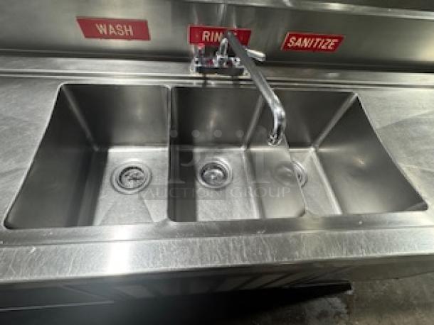 Stainless steel three-compartment sink with labeled "Wash," "Rinse," "Sanitize" sections; essential for commercial use.