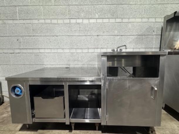 Stainless steel table with integrated single sink, storage compartments, and faucet; used condition, ideal for commercial kitchens.