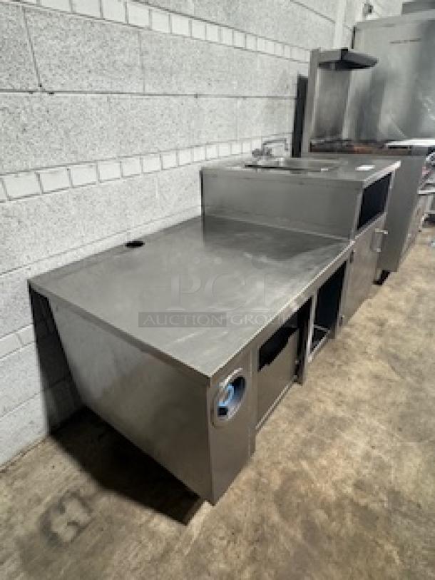 Stainless steel table with single sink, featuring storage compartments. Used condition. Ideal for commercial kitchen use.