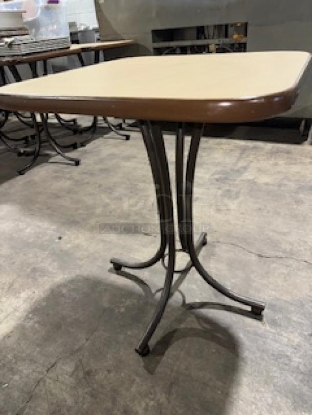 Square wooden dining table with two-tone brown finish, sturdy metal base, excellent condition. Ideal for commercial use.