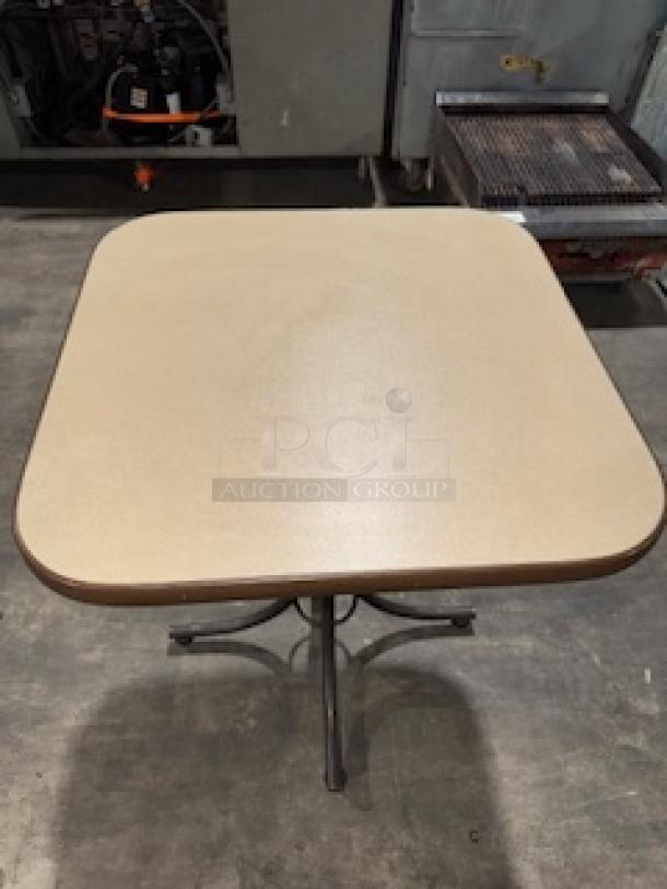 Solid commercial square dining table with two-tone brown finish. Features durable wooden construction and metal base.