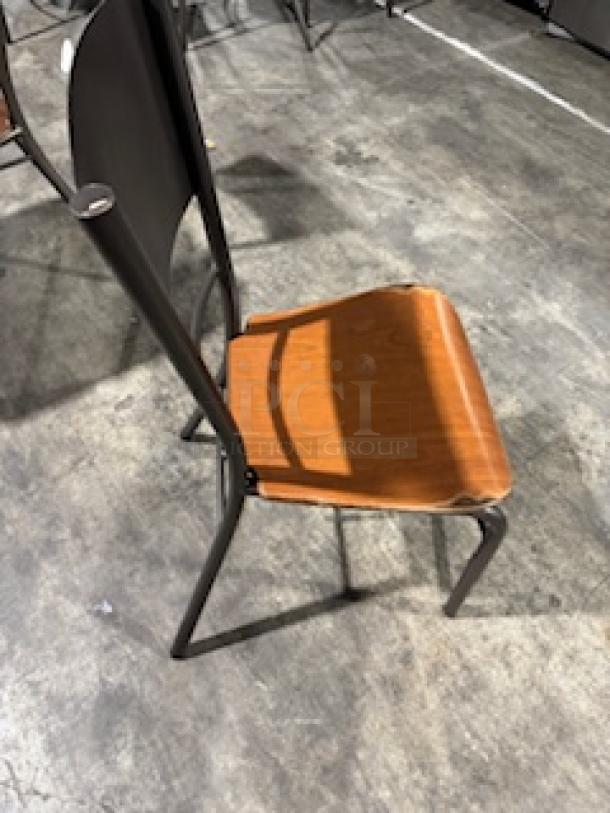 Modern dining chair with bronze base, wooden seat, and metal backrest. Good condition, suitable for contemporary decor.