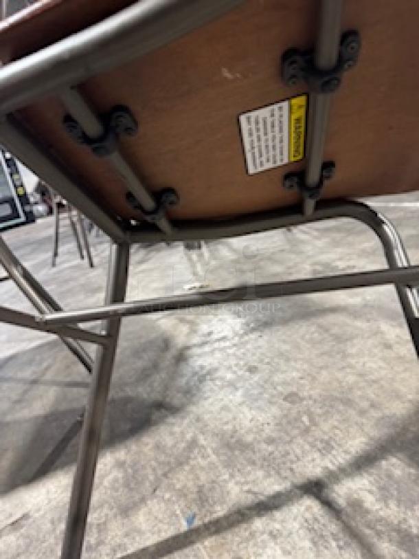 Dining chairs with bronze base, metal framework, and visible tag on underside. Sturdy, industrial design.