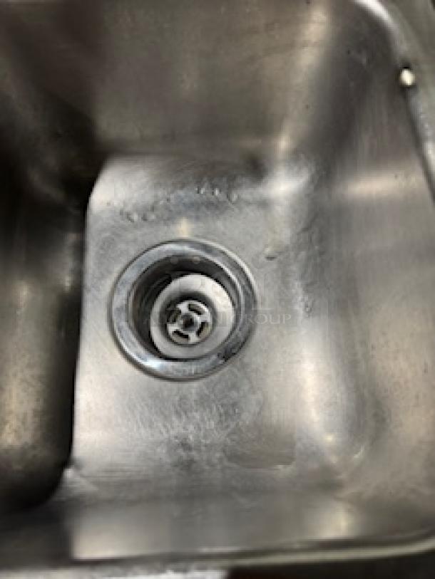 Stainless steel drop-in single sink with visible drain, moderate wear, no visible brand or faucet included.