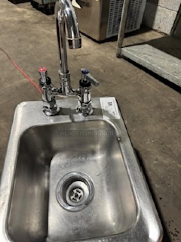 Stainless steel drop-in single sink with attached faucet, hot and cold handles, and visible drain. Good condition.