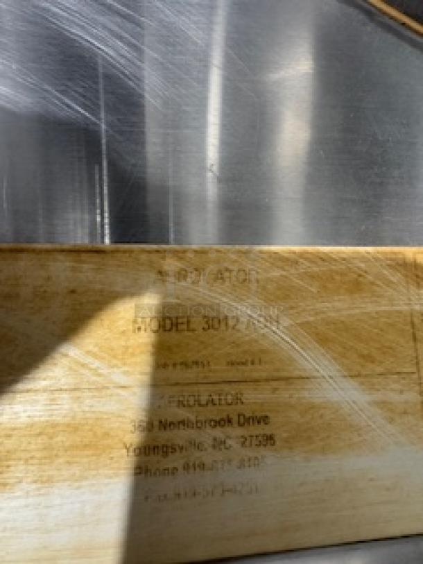 Proline stainless steel range hood detail with visible label, Model 3012. Industrial finish, reflects light. Good condition.