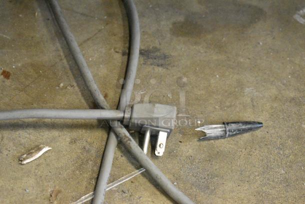 Electric cord of AHT RIO S 100 chest freezer missing plug, on commercial casters, with visible broken insulation.