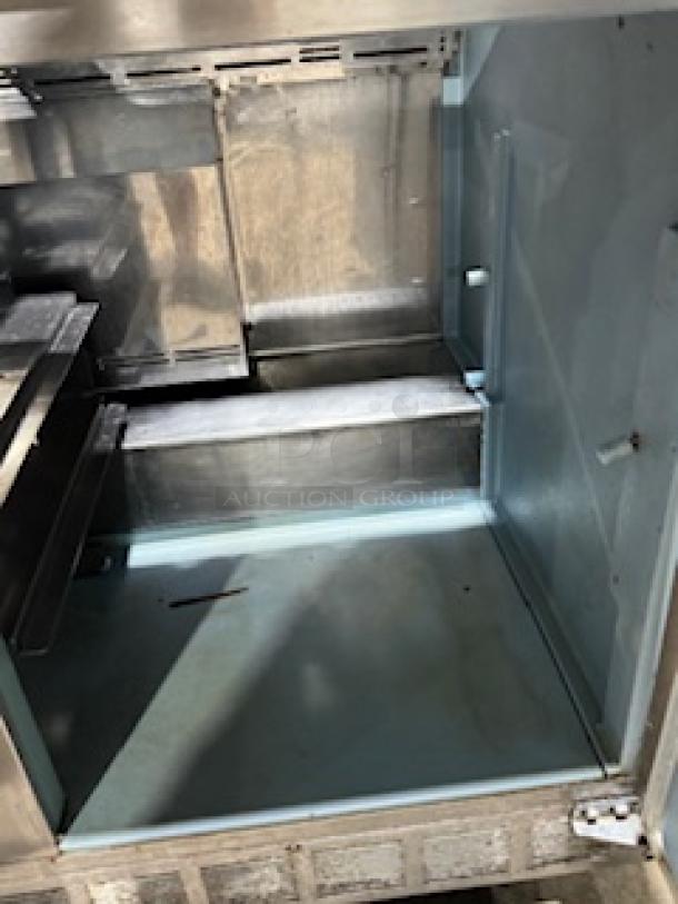 Delfield 4464NP-16 refrigerated sandwich prep table interior; clean, spacious, includes 3” casters, tested and working.