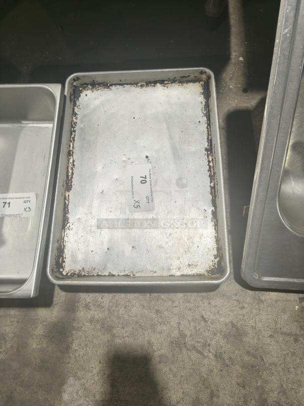 Commercial heavy-duty aluminum half-sheet pan, used condition with visible wear and markings, auction lot 70 label.