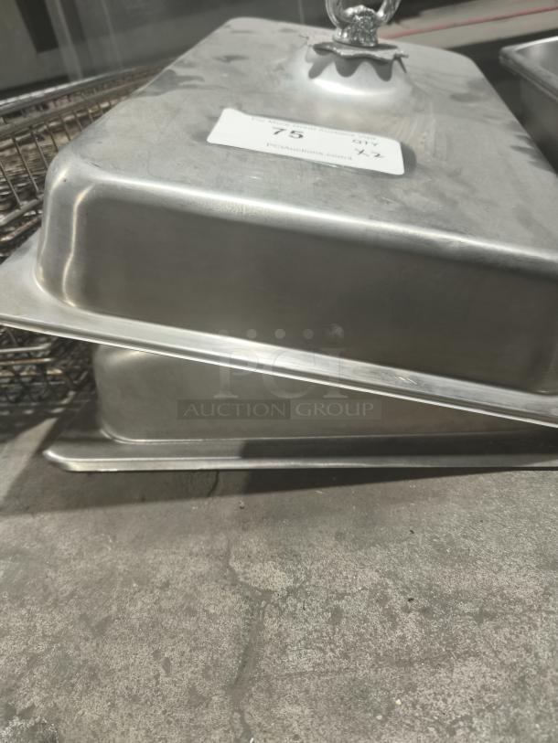 Commercial stainless steel 1/3-size hotel pan cover with decorative handle, minor surface marks, auction tag visible.