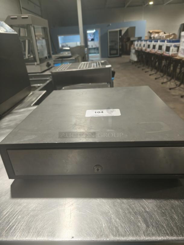 Heavy-duty steel POS cash drawer, black, with a lock on the front. Label shows "104 QTY." Sturdy for retail use.