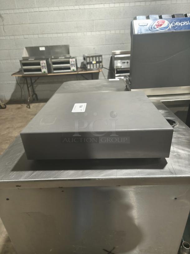 Heavy-duty steel POS cash drawer, visible wear, rectangular shape, no brand or model markings.