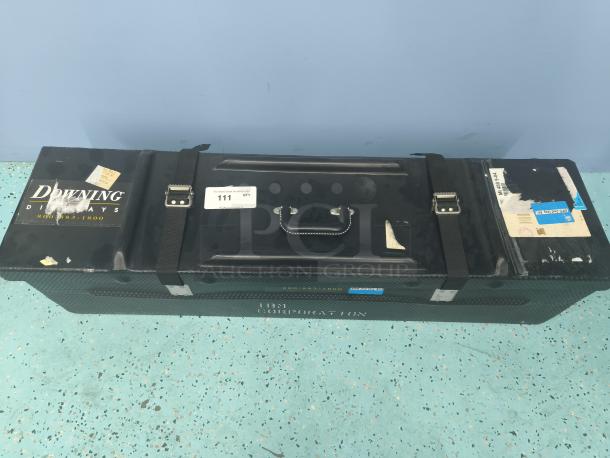 Downing Displays hard-sided trade show shipping case with handle and straps. Shows wear and labels. Text includes "800-535-1800."