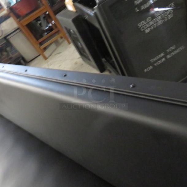 One single-sided black cushioned booth/waiting bench in excellent condition, 81x27x36 inches.