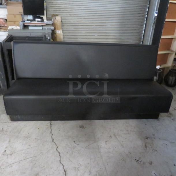 Single-sided black cushioned booth/bench, excellent condition, dimensions 81x27x36 inches.