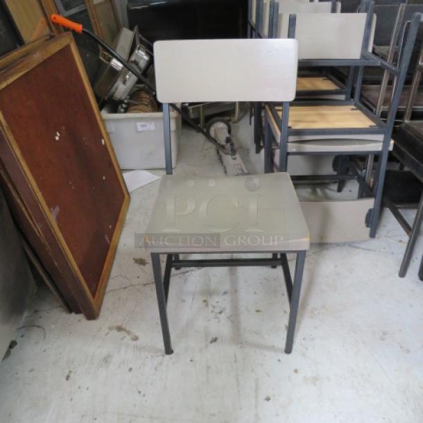 Black metal and gray wooden chair, sturdy design, clean lines, slight wear on surfaces, ideal for minimalist decor.