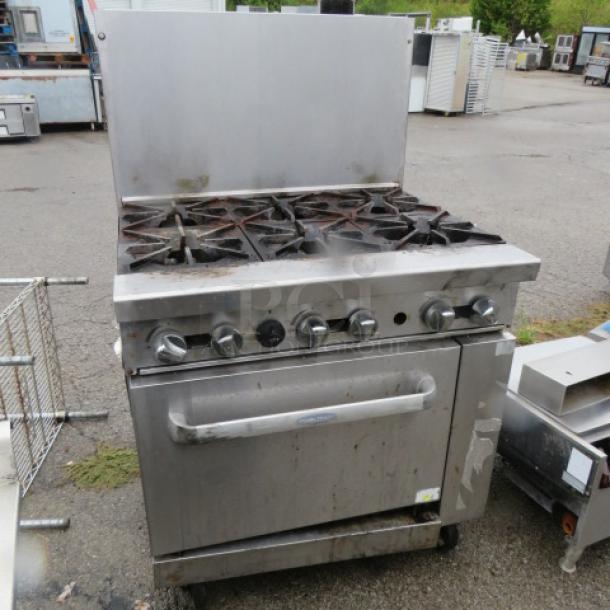 Cook Rite natural gas 6-burner range with one rack, on casters. Features stainless steel body, control knobs, and rear backsplash.