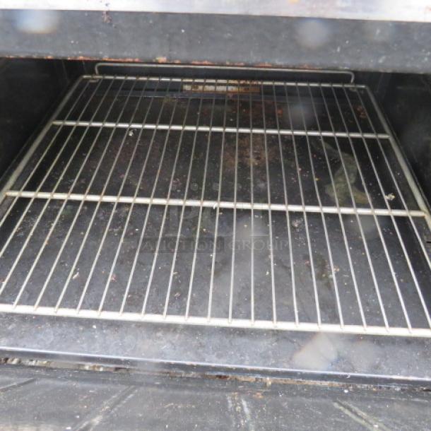 Cook Rite natural gas 6 burner range with steel rack, shown on casters. Interior view of rack included. Good condition.