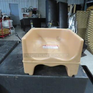 Dual-sided booster seat, beige, good condition, safety warning label visible on front, sturdy plastic construction.