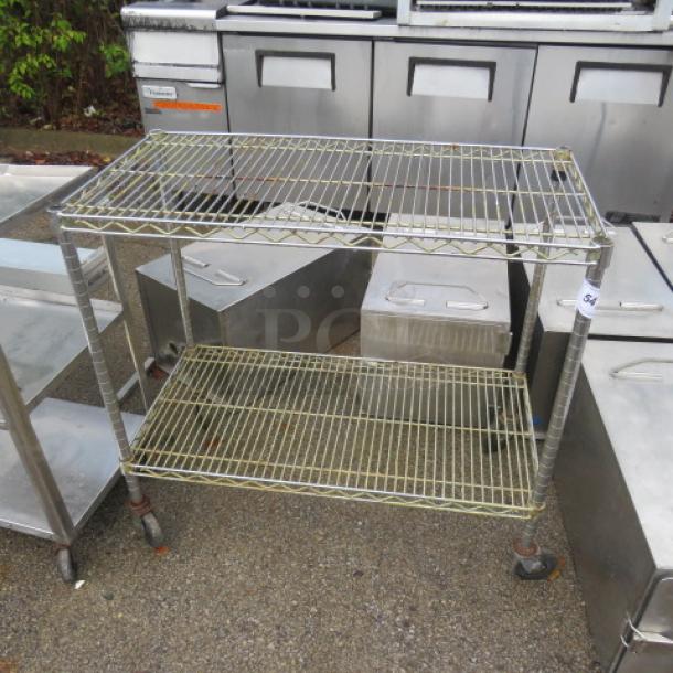 Metro shelf unit with two wire shelves on casters. Dimensions: 36x18x33 inches. Used condition, sturdy metal frame.