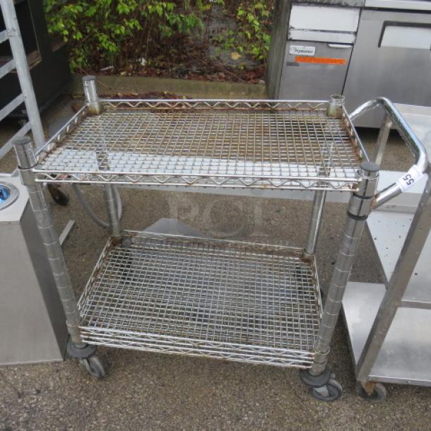 Metro cart with 3 wire shelves on casters, 34x18x33 inches, metal frame, visible wear, sturdy condition.