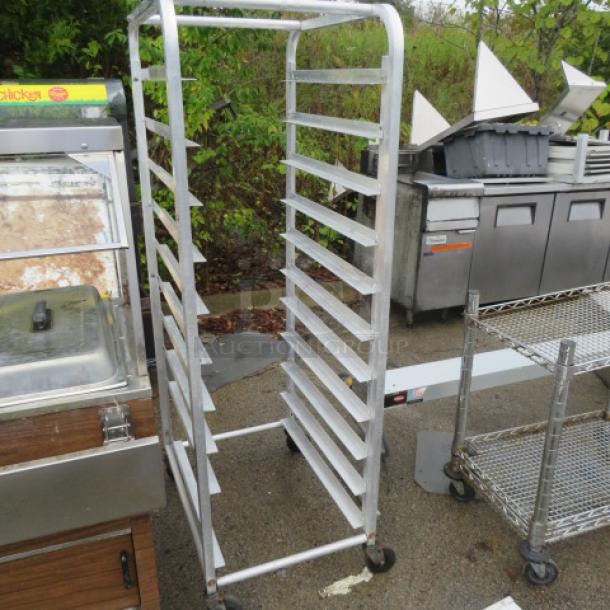 Aluminum speed rack on casters, 20.5x28x63.5 inches. Multiple shelves, good condition, ideal for commercial kitchens.