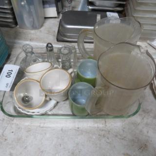 A lot of miscellaneous items including pitchers, cups, and sauce dishes on a tray; condition appears used.