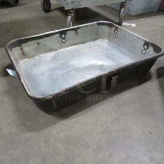 Rectangular metal roaster pan, weathered finish, with handles. Visible signs of use; no visible labels or markings.