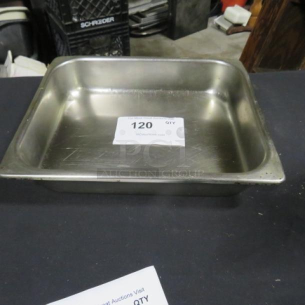Stainless steel half-size hotel pan, 2.5 inches deep, lightly used condition with surface scratches. Auction tag "120" visible inside.